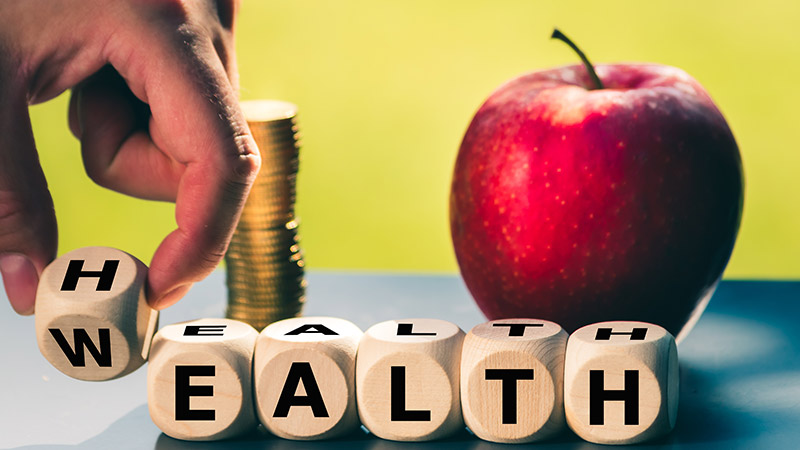 Person changing wooden blocks from wealth to health.