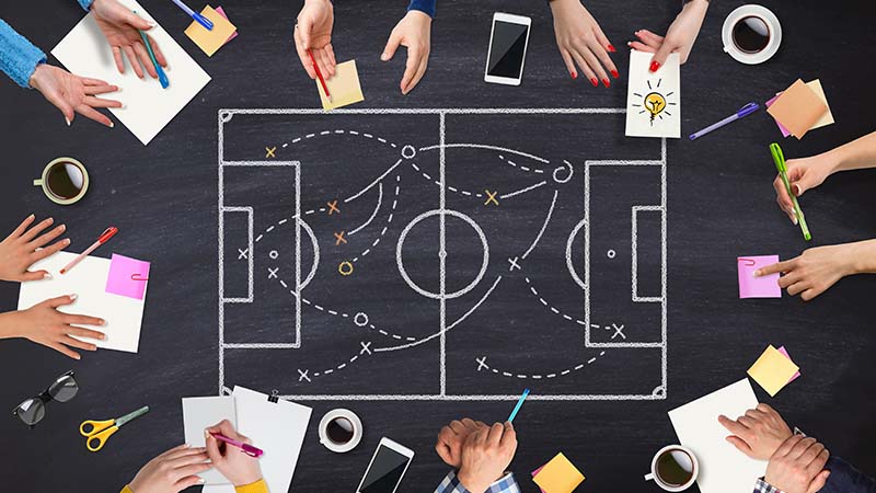 Business strategy meeting with a sports field sketch.