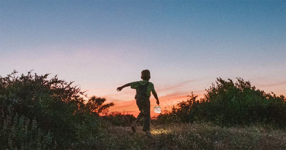 MPOWERDs Luci Light being carried by a child at sunset.