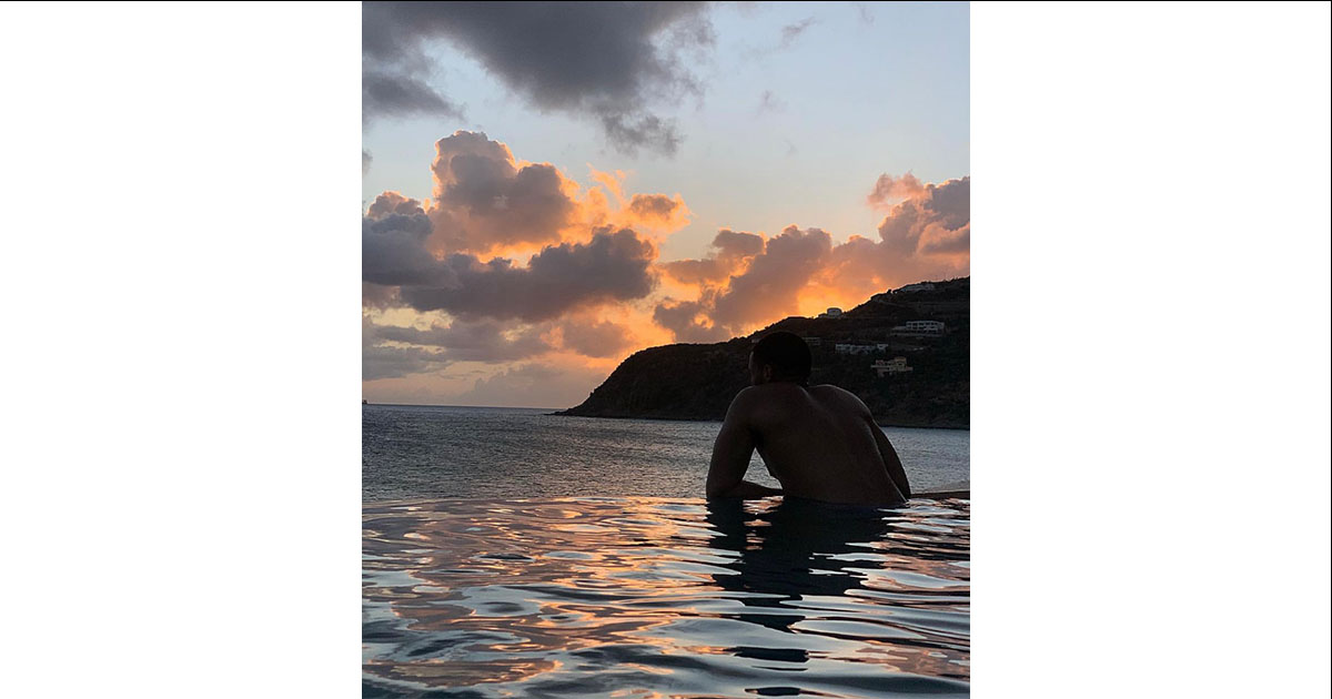 Man in pool overlooking the ocean.