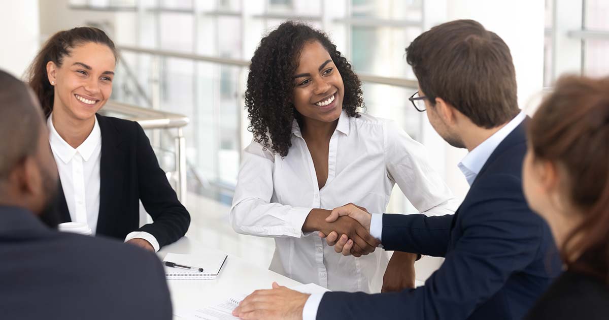 Businesswoman shaking hands with businessman.