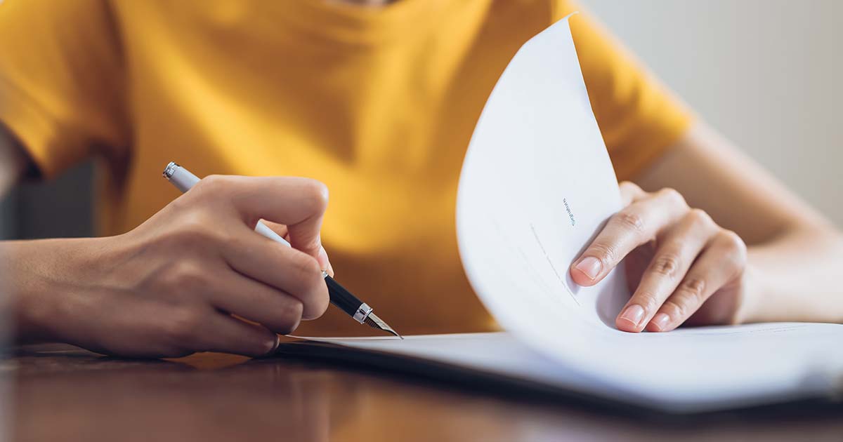 Woman signing document.