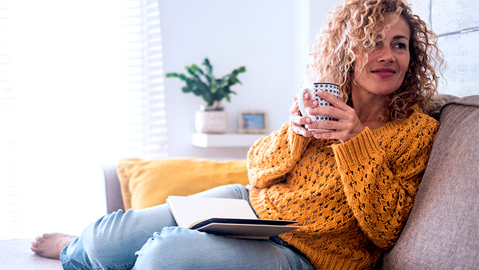 Woman relaxing on a couch, having some self-care time.